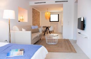 een hotelkamer met een bed en een woonkamer bij Gaviota - Emar Hotels Adults Only in Es Calo