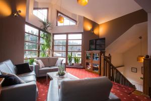 Hotel Promyk Wellness & Spa في كارباش: غرفة معيشة مع أريكة وطاولة