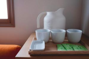 a tray with three cups and a jug on a table at SO Kyoto Fushimi Inari in Kyoto