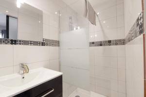 y baño blanco con lavabo y ducha. en Charming studio with parking in Sevrier along Annecy Lake - Welkeys, en Sévrier