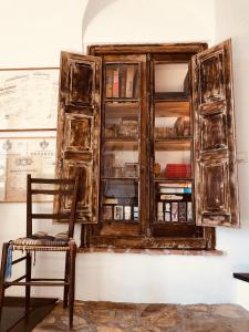 an old wooden cabinet on a wall with a chair at Bed and breakfast Ca du 5 in Tovo San Giacomo