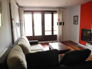 un soggiorno con un divano e una TV di VIVIENDA TURÍSTICA LOS OLIVOS a Fontellas