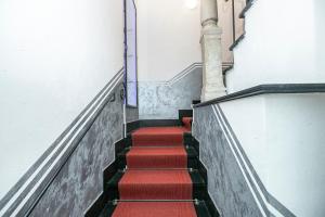 a set of stairs with red carpeting in a building at Torre degli Orefici dimora medioevale in Genoa