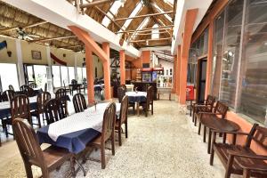 蒂卡尔Hotel Tikal Inn的有桌椅和窗户的餐厅