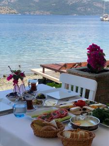 a white table with food on it next to the water at Beyaz İskele Hotel & Restaurant in Selimiye