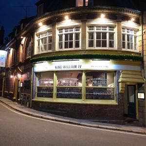 una tienda frente a un edificio en una calle por la noche en King William IV, en Totnes