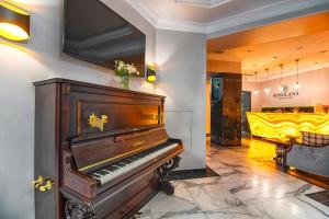 a piano in a room with a bed at Grand Hotel Roxolana in Ivano-Frankivsk