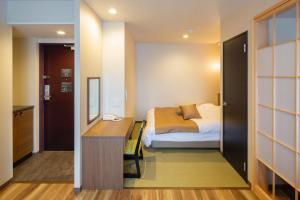 um quarto com uma cama e uma secretária num quarto em Hotel Imari Aioibashi Bettei em Imari