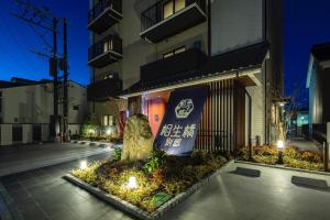伊万里市Hotel Imari Aioibashi Bettei的建筑物前有树的建筑物