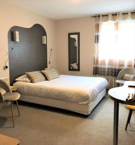 1 dormitorio con 1 cama grande y espejo en Auv'hôtel, en Mauriac
