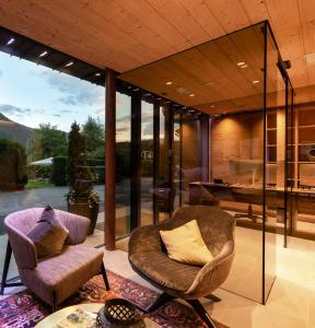 a living room with two chairs and a table at Anewandter Historic Hotel in Brunico