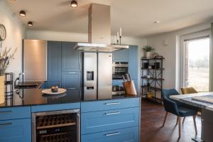 a kitchen with blue cabinets and a table with chairs at Wohnung Freiblick in Bastorf