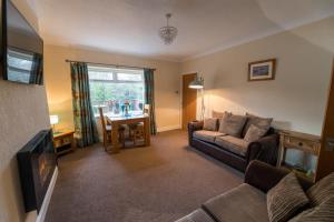uma sala de estar com um sofá e uma mesa em Host & Stay - Poppy Cottage em Bamburgh