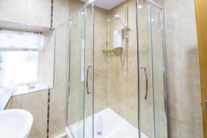 a bathroom with a shower and a toilet and a sink at Host & Stay - Poppy Cottage in Bamburgh +21 photos