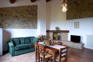 a living room with a table and a green couch at San Giorgio Country Residence in Santa Luce