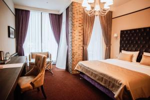 a hotel room with a bed and a desk and window at VERTEX SPA hotel in Estosadok