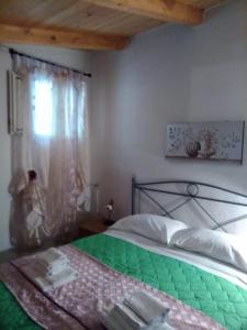 Un dormitorio con una cama verde y una ventana en CASA VACANZE CLIO - PISCIOTTA/PALINURO, en Pisciotta