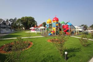 a park with a playground with a play yard at DOMY MARINA VILLAGE in Kąty Rybackie