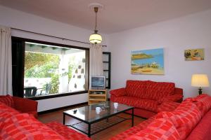 a living room with two red couches and a tv at Finca la Crucita Haria Lanzarote By PVL in Haría