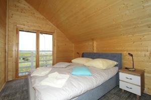 a bedroom with a bed in a wooden cabin at DOMY MARINA VILLAGE in Kąty Rybackie +14 photos