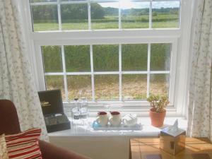 een tafel voor een raam met wijnglazen bij St Quintin Arms in Harpham