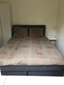 a bed with red numbers on it in a bedroom at Bungalows Hoefbos in Otterlo