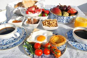 
a table topped with plates of food and bowls of fruit at The Birds Nest in Alvor
