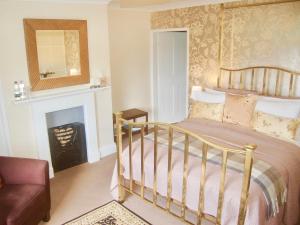 a bedroom with a bed with a fireplace and a mirror at St Quintin Arms in Harpham