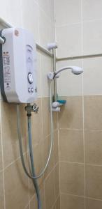 a shower in a bathroom with a water tank at D'merbau Homestay & Laman Kahwin Sg Buloh in Merbau Sempak