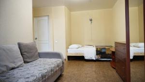 een slaapkamer met 2 bedden, een bank en een dressoir bij Doba In Ua Hoholya Apartments in Dnipro