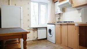 een keuken met een wasmachine en een raam bij Doba In Ua Hoholya Apartments in Dnipro