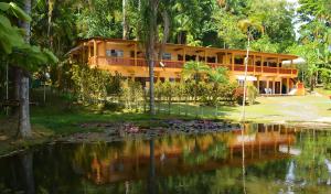 a resort with a pond in front of a building at Pousada Recanto do Morro in Cananéia