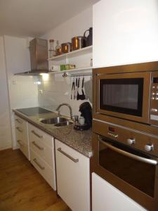 cocina con fregadero y microondas en Pension Edelweiss, apartment Amsterdam 4-6 pers, en Gosau