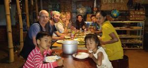 Un groupe de personnes assises autour d'une table et mangeant de la nourriture dans l'établissement Ratanakiri Homestay & Jungle Trek, à Banlung