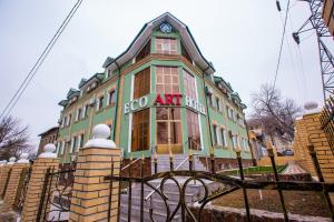een groen gebouw met een klok erop bij ART ECO HOTEL in Tasjkent
