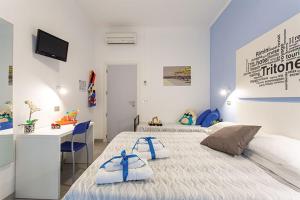 a bedroom with two beds and a desk and a computer at Hotel Tritone Rimini in Rimini