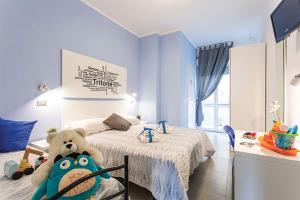 a teddy bear sitting on a chair in a bedroom at Hotel Tritone Rimini in Rimini