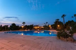 a large swimming pool at night with palm trees at Antica Masseria Li Sauli in Gallipoli