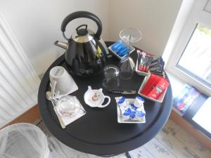 a black table with a tea kettle on top of it at Villa Farm Cottage in Thornton Curtis