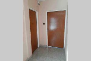 a hallway with a brown door and a doorway at EN EL CORAZON DE SALTA PASADO PRESENTE Y FUTURO in Salta