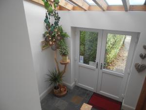 un couloir avec une porte blanche et une plante dans l'établissement Villa Farm Cottage, à Thornton Curtis