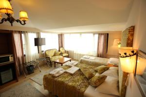 a bedroom with a large bed and a living room at Hotel Tashkonak Istanbul in Istanbul