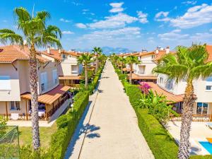 a street in a resort with palm trees at Paradise Town Villa Beltania in Belek