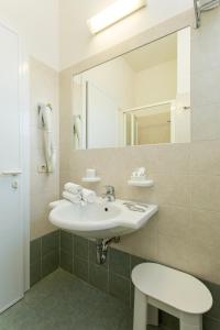 a bathroom with a sink and a mirror at Hotel Tritone Rimini in Rimini