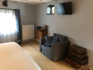 a living room with a couch and a television at Cuerne bed&breakfast in Kuurne