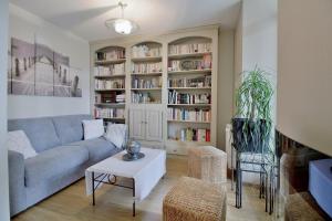 a living room with a couch and a book shelf at Le Balcon du Parc, entre Lourdes et Gavarnie in Argelès-Gazost