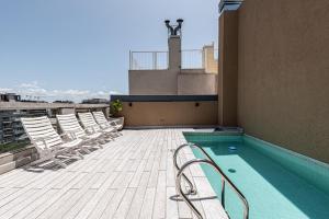 - un balcon avec des chaises et une piscine dans un bâtiment dans l'établissement Imperdible departamento en excelente ubicacion, à Buenos Aires