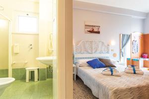 a bedroom with a bed and a tub and a sink at Hotel Tritone Rimini in Rimini