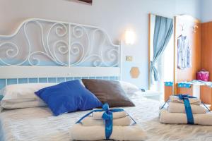 a bedroom with a large bed with two towels on it at Hotel Tritone Rimini in Rimini