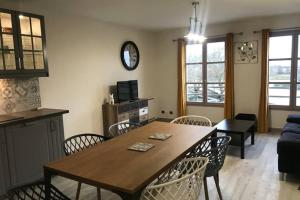 - un salon avec une table et des chaises en bois dans l'établissement Appartement vue sur le pont, à Honfleur